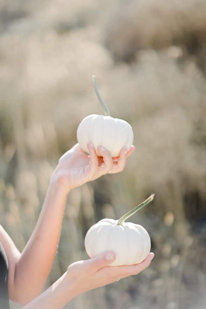 Kath Eats Blogger Kath Younger shares Healthy Habits For Fall: in photo: person holding two white small pumpkins