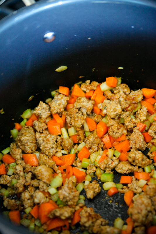 chopped vegetables and sausage in a deep pot