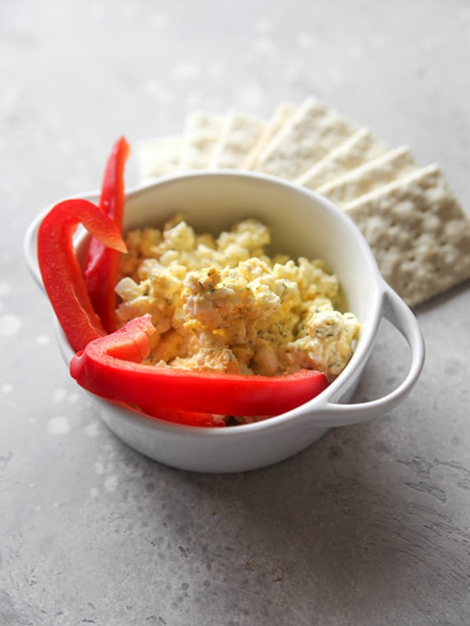 egg salad with red peppers in a white bowl