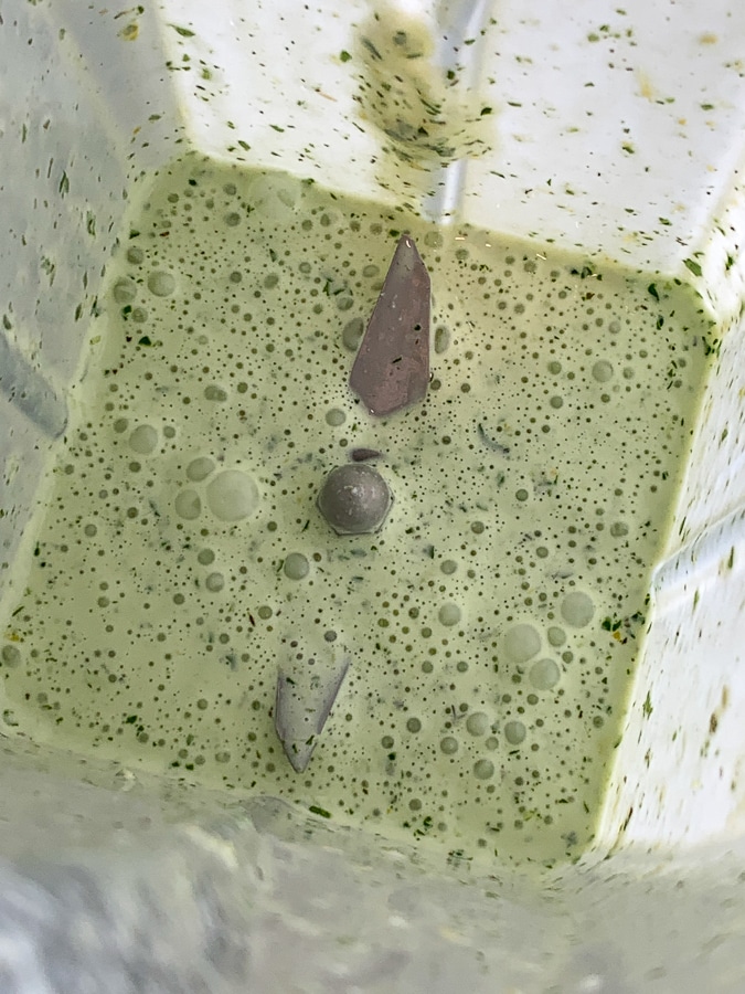 blended up herb dressing in the bottom of a blender
