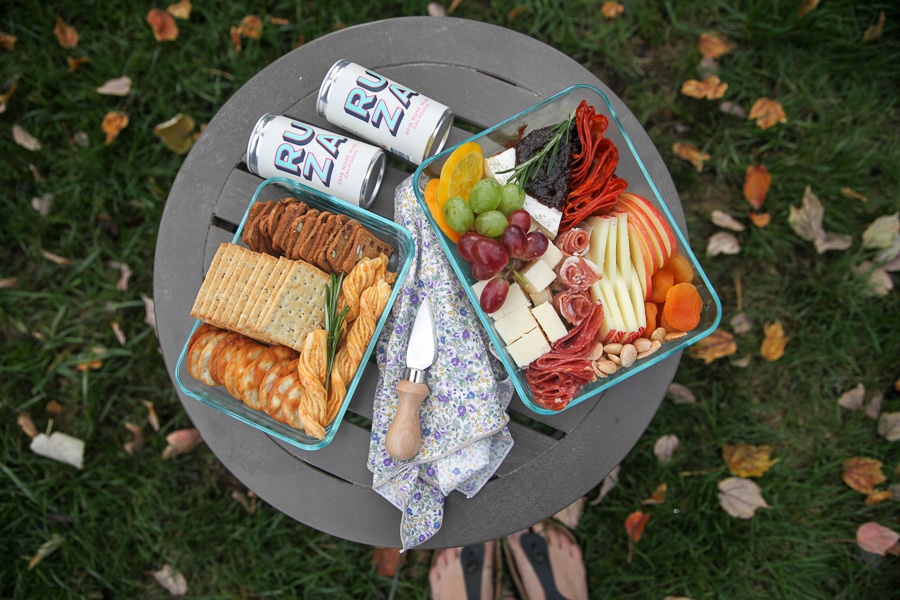 picnic cheese board from above with crackers, cheese straws and wine