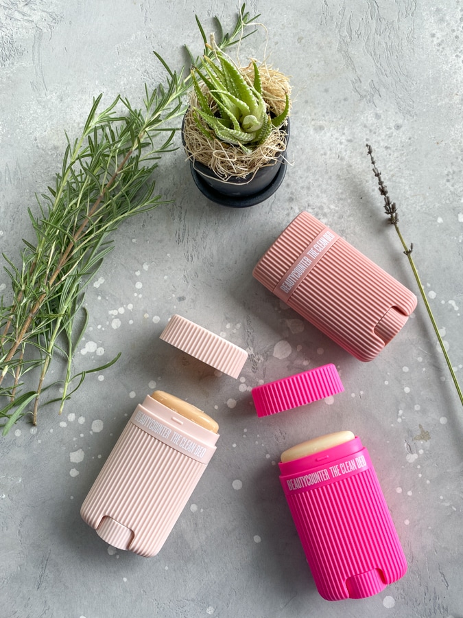 Beautycounter clean deo on a gray cement table with plants