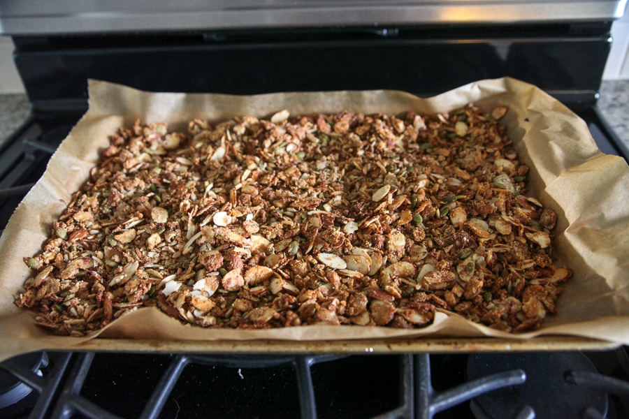 toasted granola on a sheet pan coming out of oven