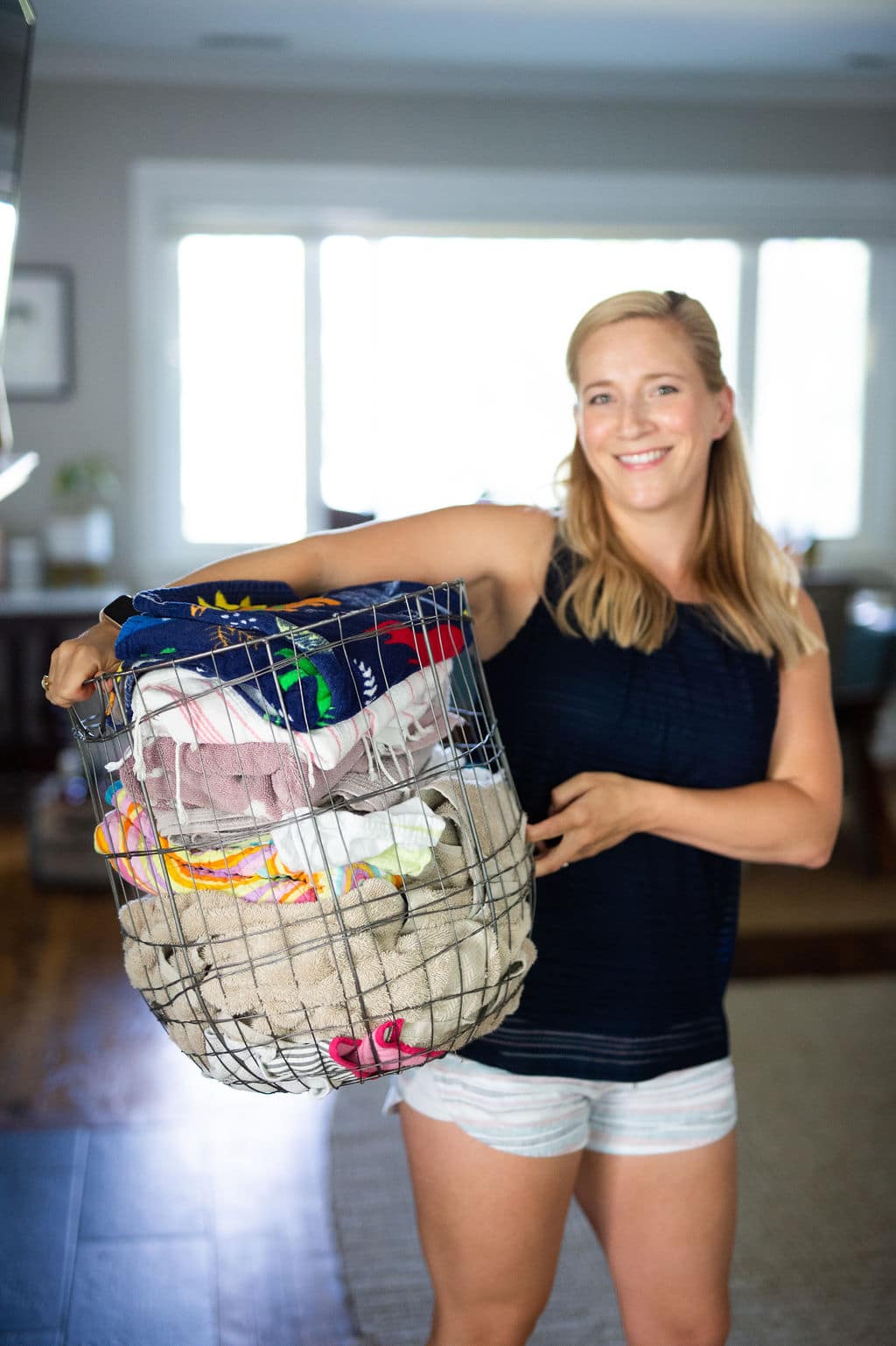 Kath Younger holding wire basket full of laundry.