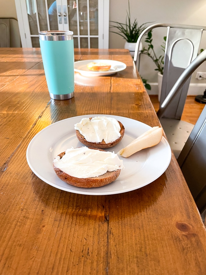 bagels on a table with white plates and coffee