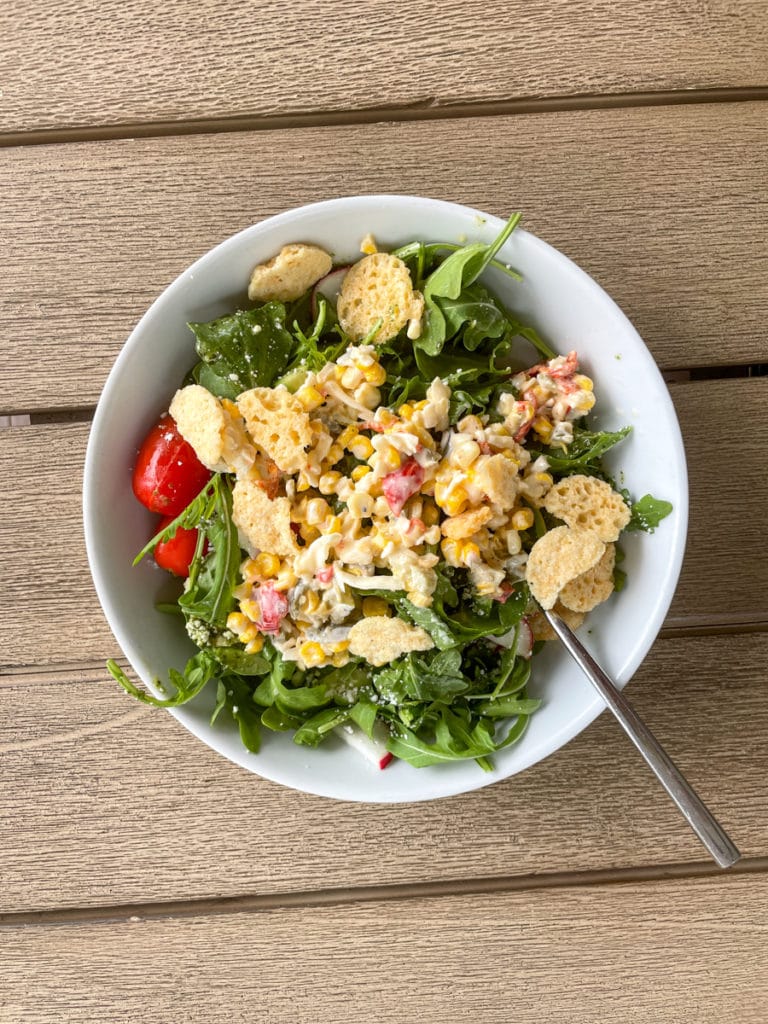 Salad with all kinds of leftovers on top.
