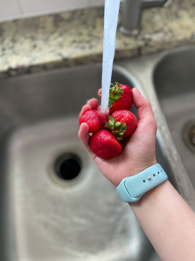 washing strawberries in the sink
