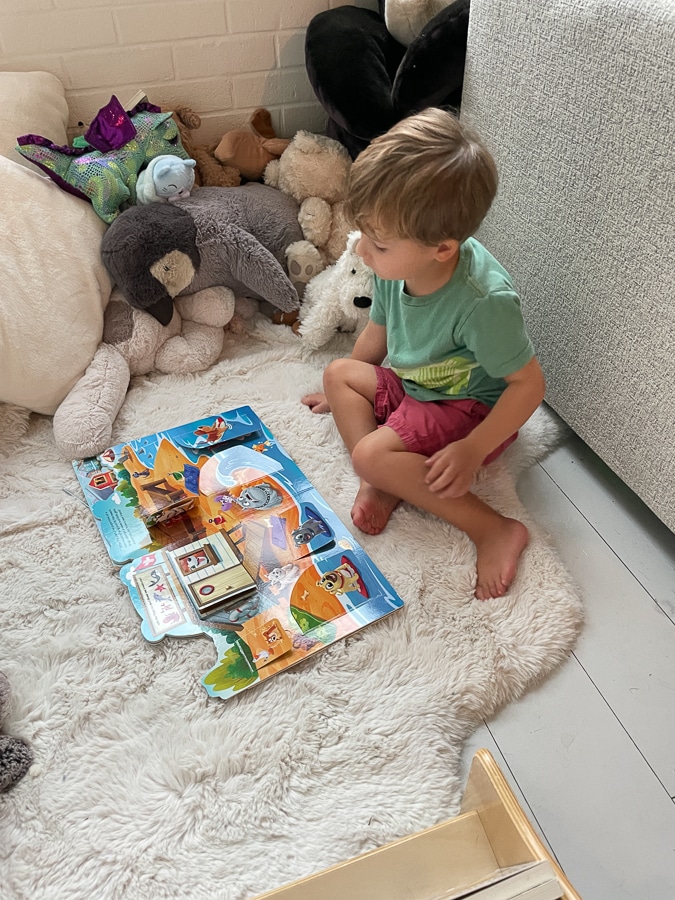 Little boy surrounded by stuffed toys