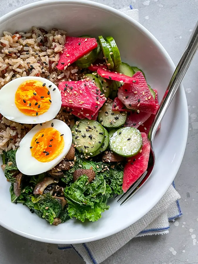 Grain bowl with soft boiled egg, radish, cucumbers