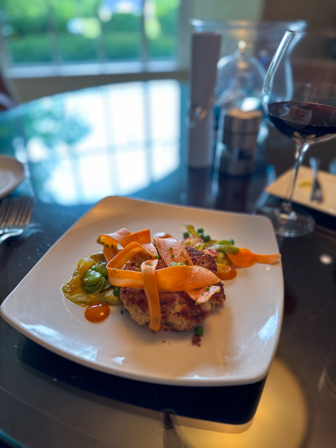 crab cake with carrot ribbons, greens, and fava bean hummus. 