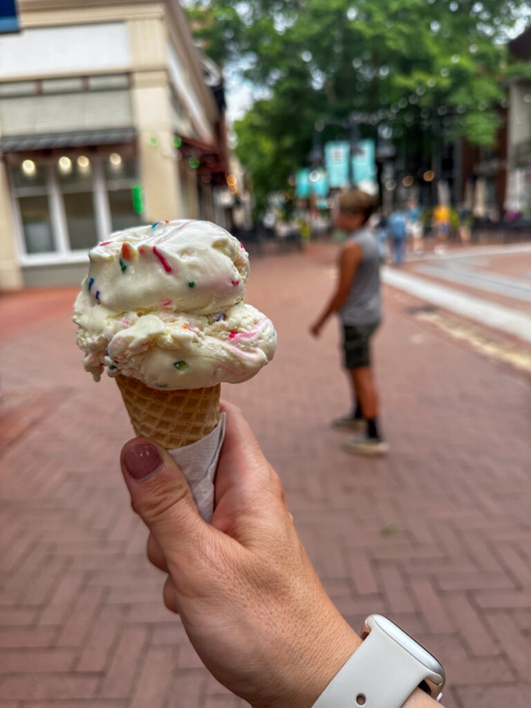 person holding a cone with ice cream